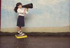 Young Business Girl Yells Through Megaphone